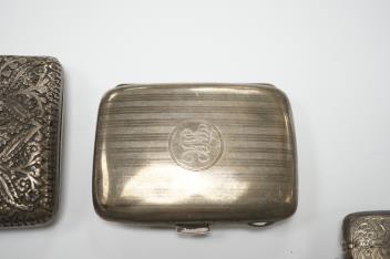 Three assorted silver cigarette cases including Art Deco, largest 10.1cm, a silver vesta case and a white metal cigarette case.